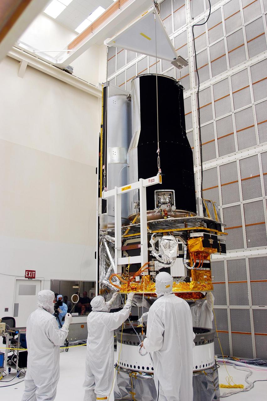 KENNEDY SPACE CENTER, FLA. - Workers make additional adjustments on the Space Infrared Telescope Facility (SIRTF) in Building AE. The telescope will be mated with its Delta II launch vehicle via the payload attach fitting seen beneath it. SIRTF is currently scheduled for transportation to Launch Complex 17-B, Cape Canaveral Air Force Station, and hoisting atop the Delta II on or about April 4.