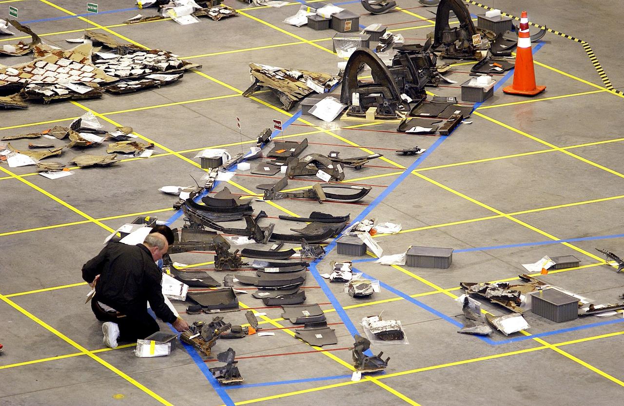 KENNEDY SPACE CENTER, FLA. -   Pieces of Columbia debris are beginning to fill one area of the Shuttle painted on the floor of the RLV Hangar.  Approximately 4,500 ground searchers have covered approximately 56 percent of the planned 555,000-acre search area. About 28 percent of the Shuttle Columbia, by weight, has been delivered to the RLV Hangar to date.