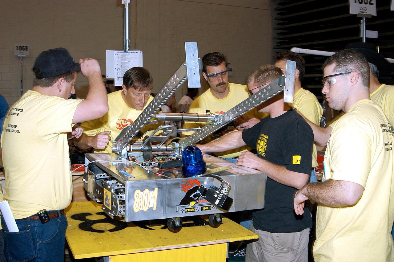 KENNEDY SPACE CENTER, FLA. -  Members of the Merritt Island and Edgewood Middle School students/Lockheed Martin team look over their robot.  They are participating in the 2003 Southeastern  Regional FIRST Robotic Competition being held at the University of Central Florida (UCF) in Orlando, March 20-23. Forty teams from around the country are participating in the event that pits team-built gladiator robots against each other in an athletic-style competition. The teams are sponsored by NASA-Kennedy Space Center, The Boeing Company/Brevard Community College, and Lockheed Martin Space Operations/Mission Systems for the nonprofit organization For Inspiration and Recognition of Science and Technology, known as FIRST. The vision of FIRST is to inspire in the youth of our nation an appreciation of science and technology and an understanding that mastering these disciplines can enrich the lives of all mankind.