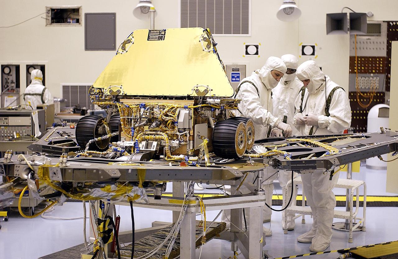 KENNEDY SPACE CENTER, FLA. -- In the Payload Hazardous Servicing Facility, the Mars Exploration Rover 2 (MER-2) has been installed on the base petal of the lander and the solar arrays have been stowed for flight. The cruise stage is in the background. There are two rovers, identical to each other, and each will land at different regions of Mars. They are designed to cover roughly 110 yards each Martian day over various terrain. Each rover will carry five scientific instruments that will allow it to search for evidence of liquid water that may have been present in the planet's past. The first rover has a launch window opening May 30, and the second rover a window opening June 25.