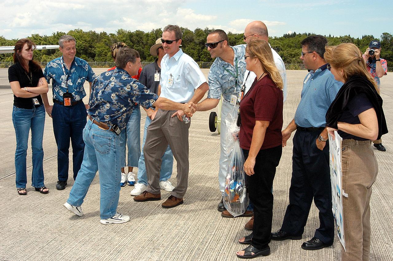 KENNEDY SPACE CENTER, FLA. - Ron Dale (left, foreground) is greeted by friends and co-workers on his return to KSC.  Dale, with the NASA Safety and Process Assurance Branch at KSC, was aboard a helicopter that crashed while searching for debris from the Space Shuttle Columbia in east Texas in March.   He was treated for nonlife-threatening injuries and recently released.