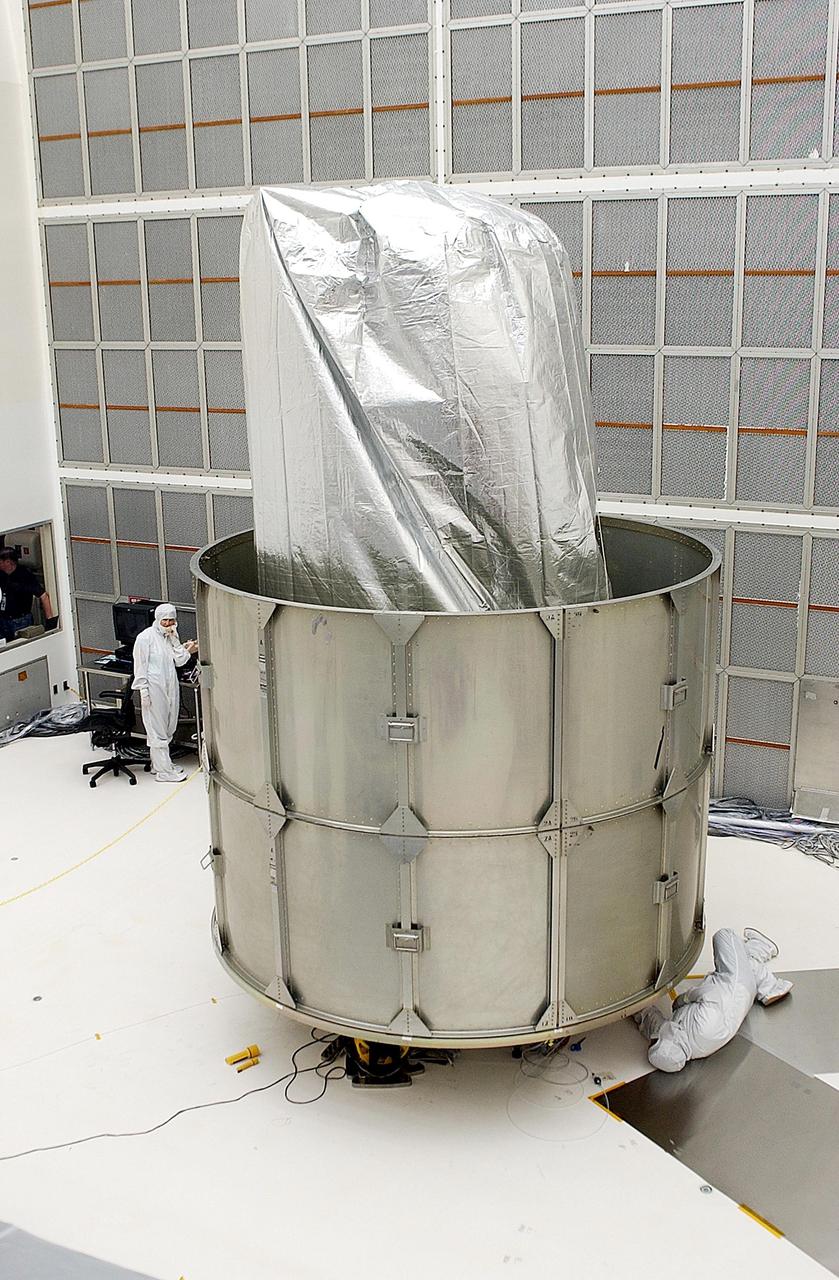 KENNEDY SPACE CENTER, FLA. - The partially enclosed Space Infrared Telescope Facility (SIRTF) waits for installation of the top two rings of the payload canister. SIRTF is currently scheduled for transportation to Launch Complex 17-B, Cape Canaveral Air Force Station, and mating with the Delta II on or about April 4.