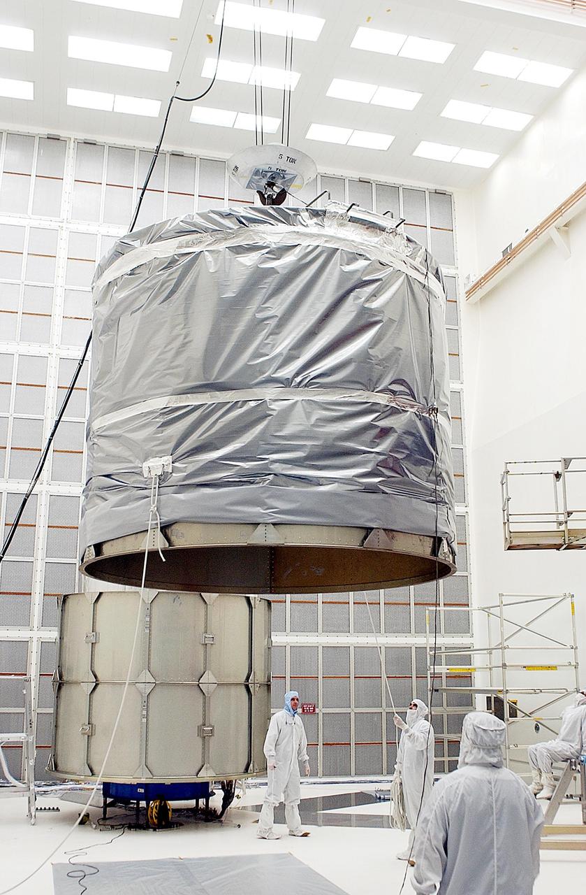 KENNEDY SPACE CENTER, FLA. -- The top rings of the payload canister are lifted by crane to move to the Space Infrared Telescope Facility (SIRTF) behind them. After installation, SIRTF will be transported to Launch Complex 17-B, Cape Canaveral Air Force Station, and mating with the Delta II on or about April 4.