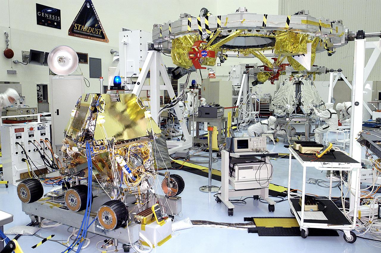 KENNEDY SPACE CENTER, FLA. - In the Payload Hazardous Servicing Facility, both Mars Exploration Rovers (MER) can be seen, MER-1 at left and MER-2 in the background. Workers are preparing the shrouded MER-2 for mating to the lander. Set to launch in Spring 2003, the MER Mission consists of two identical rovers, landing at different regions of Mars, designed to cover roughly 110 yards each Martian day over various terrain. Each rover will carry five scientific instruments that will allow it to search for evidence of liquid water that may have been present in the planet's past. The first rover has a launch window opening May 30, and the second rover a window opening June 25.