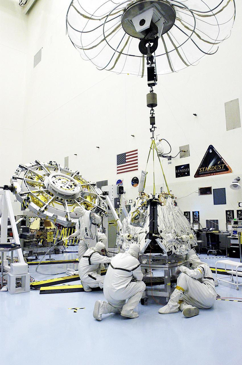 KENNEDY SPACE CENTER, FLA. -  Workers in the Payload Hazardous Servicing Facility check the Mars Exploration Rover 2 (MER-2) before it is lifted and moved to the lander where it will be mated to the base petal.  Set to launch in Spring 2003, the MER Mission consists of two identical rovers, landing at different regions of Mars, designed to cover roughly 110 yards each Martian day over various terrain. Each rover will carry five scientific instruments that will allow it to search for evidence of liquid water that may have been present in the planet's past.  The first rover has a launch window opening May 30, and the second rover a window opening June 25.