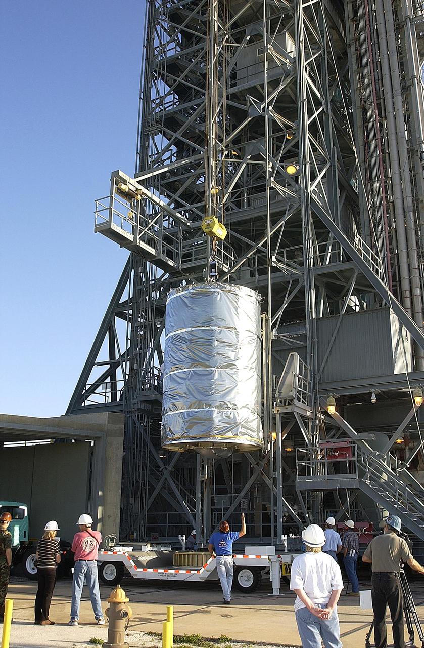 KENNEDY SPACE CENTER, FLA. -- The payload canister with the Space Infrared Telescope Facility (SIRTF) inside is lifted up the tower on Launch Complex 17-B, Cape Canaveral Air Force Station.   SIRTF will be mated with the Delta II launch vehicle in the tower. SIRTF will obtain images and spectra by detecting the infrared energy, or heat, radiated by objects in space. Most of this infrared radiation is blocked by the Earth's atmosphere and cannot be observed from the ground. Consisting of an 0.85-meter telescope and three cryogenically cooled science instruments, SIRTF is one of NASA's largest infrared telescopes to be launched.