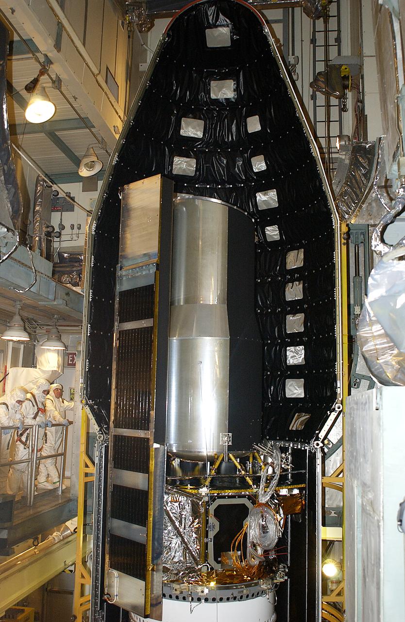 In the launch tower on Launch Complex 17-B, Cape Canaveral Air Force Station, the first part of the fairing is seen in place around the Space Infrared Telescope Facility (SIRTF). SIRTF will obtain images and spectra by detecting the infrared energy, or heat, radiated by objects in space. Most of this infrared radiation is blocked by the Earth's atmosphere and cannot be observed from the ground. Consisting of an 0.85-meter telescope and three cryogenically cooled science instruments, SIRTF is one of NASA's largest infrared telescopes to be launched. SIRTF is currently scheduled for launch April 18 aboard a Delta II rocket from Launch Complex 17-B, Cape Canaveral Air Force Station.