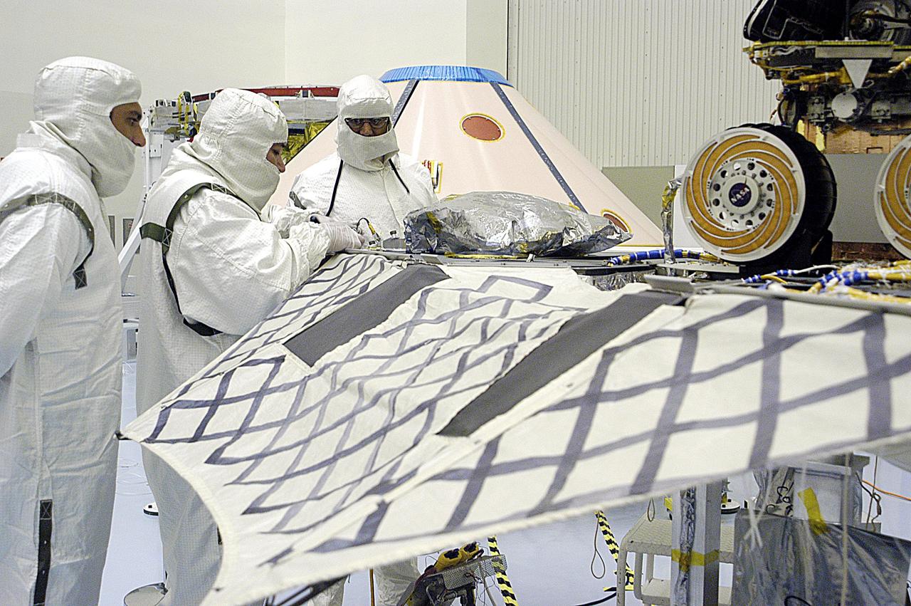 KENNEDY SPACE CENTER, FLA. -- In the Payload Hazardous Servicing Facility, technicians prepare to close the lander petals and attached airbags of the Mars Exploration Rover 2 (MER-2) around the spacecraft prior to launch. The MER Mission consists of two identical rovers set to launch in Spring 2003. Landing at different regions of Mars, they are designed to cover roughly 110 yards each Martian day over various terrain. Each rover will carry five scientific instruments that will allow it to search for evidence of liquid water that may have been present in the planet's past.