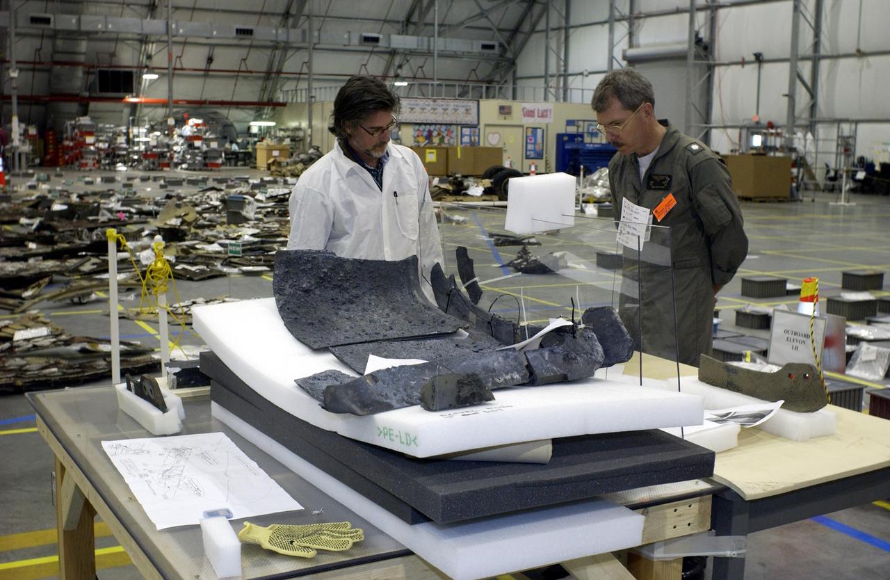 KENNEDY SPACE CENTER, FLA. -- Members of the Columbia Reconstruction Project Team look over pieces of debris in the KSC RLV Hangar. Shipped from Barksdale Air Force Base, Shreveport, La., more than 70,000 items, weighing 78,000 pounds, about 36 percent of the Shuttle by weight, have been delivered to KSC for use in the mishap investigation. Ground teams have completed 78 percent of their primary search area, and airborne crews finished 80 percent of their assigned area. Search teams have completed 98 percent of the underwater searches in Lake Nacogdoches and Toledo Bend Reservoir.