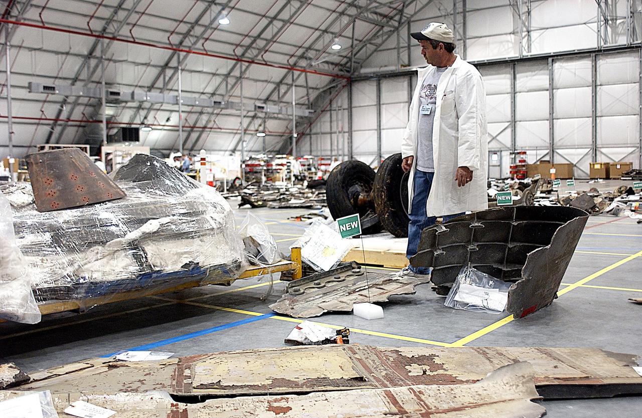 KENNEDY SPACE CENTER, FLA. -- A member of the Columbia Reconstruction Project Team looks over pieces of debris on the floor of the KSC RLV Hangar. Shipped from Barksdale Air Force Base, Shreveport, La., more than 70,000 items, weighing 78,000 pounds, about 36 percent of the Shuttle by weight, have been delivered to KSC for use in the mishap investigation. Ground teams have completed 78 percent of their primary search area, and airborne crews finished 80 percent of their assigned area. Search teams have completed 98 percent of the underwater searches in Lake Nacogdoches and Toledo Bend Reservoir.
