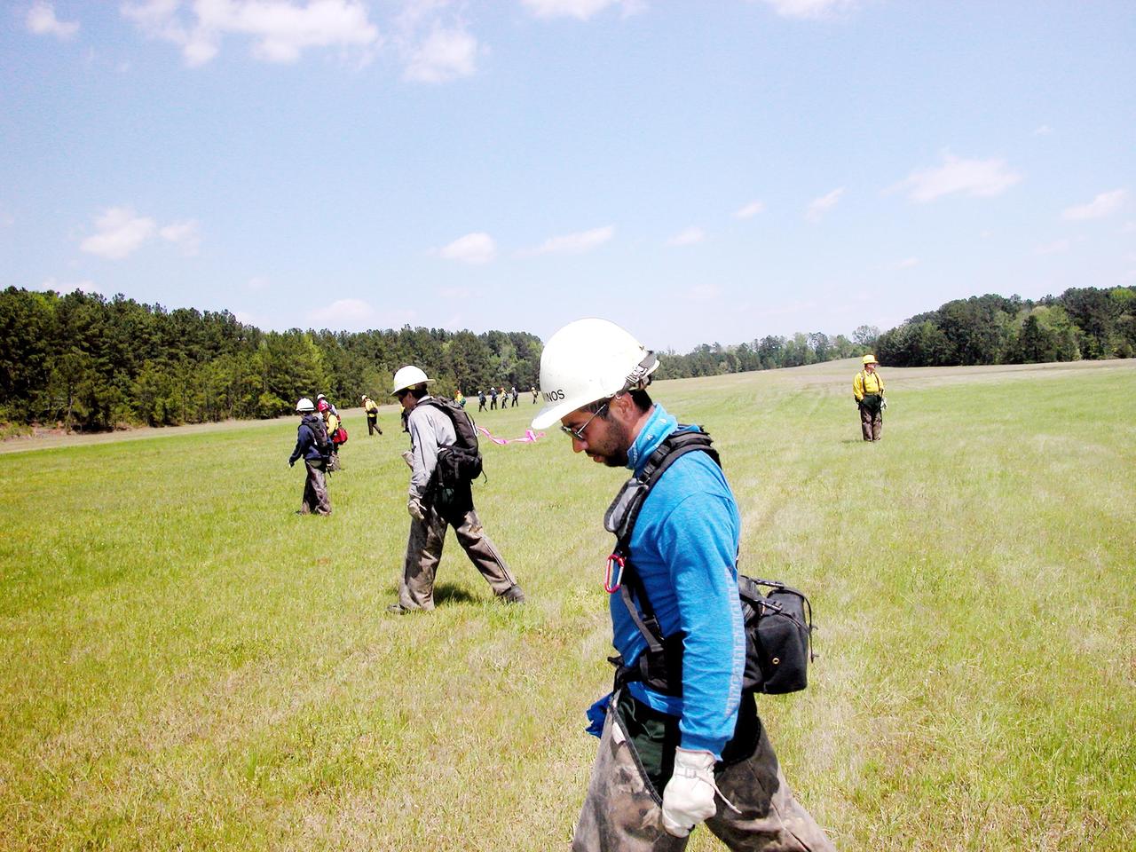 KENNEDY SPACE CENTER, FLA. -- Members of a U.S. Forest Service search team walk a grid during a Columbia Recovery search near the Nacogdoches site. The group is accompanied by a space program worker able to identify potential hazards of Shuttle parts. Kennedy Space Center workers are participating in the Columbia Recovery efforts at the Lufkin (Texas) Command Center, four field sites in East Texas, and the Barksdale, La., hangar site. KSC is working with representatives from other NASA Centers and with those from a number of federal, state and local agencies in the recovery effort. KSC provides vehicle technical expertise in the field to identify, collect and return Shuttle hardware to KSC.