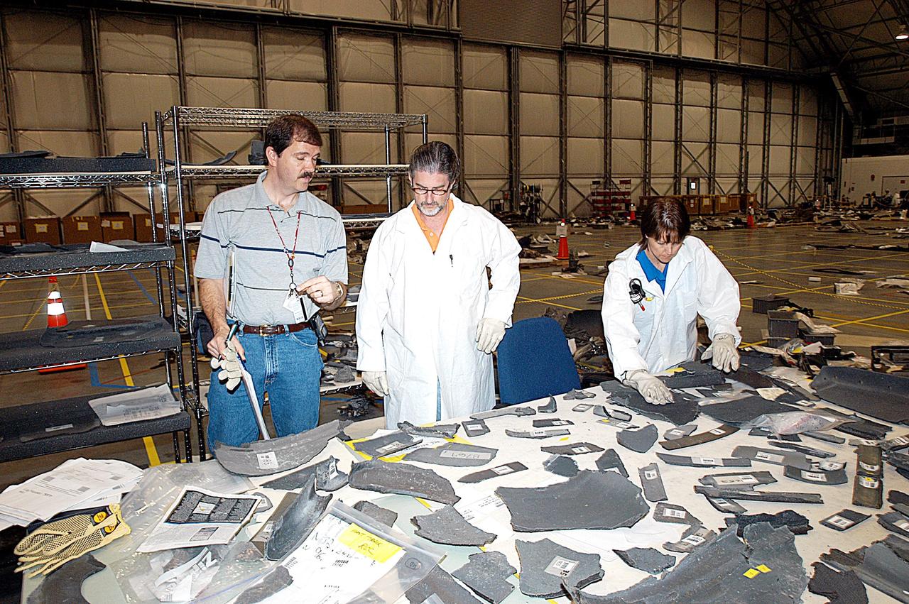KENNEDY SPACE CENTER, FLA. -- Members of the Columbia Reconstruction Project team work at identifying pieces of Columbia debris delivered to the RLV Hangar. Shipped from Barksdale Air Force Base, Shreveport, La., more than 70,000 items, weighing 78,000 pounds, about 36 percent of the Shuttle by weight, have been delivered to KSC for use in the mishap investigation. Ground teams have completed 78 percent of their primary search area, and airborne crews finished 80 percent of their assigned area. Search teams have completed 98 percent of the underwater searches in Lake Nacogdoches and Toledo Bend Reservoir.
