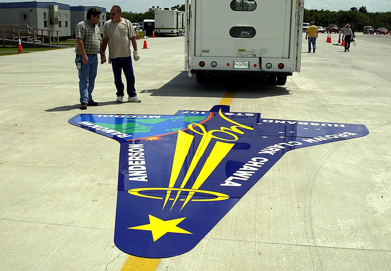 KENNEDY SPACE CENTER, FLA. -- Workers deliver an enlarged replica of the STS-107 crew emblem to the RLV Hangar where it will be installed on an outside wall.  Inside the hangar, members of the Columbia Reconstruction Project team are identifying pieces of Columbia debris as they arrive at Kennedy Space Center and placing them on a grid approximating the shape of the orbiter.