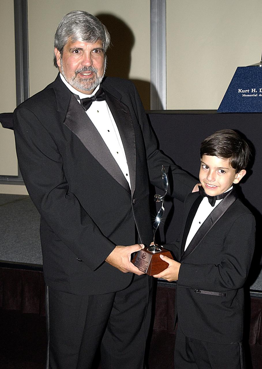KENNEDY SPACE CENTER, FLA. -- Adrian Laffitte (left) and his son show off a small copy of the Debus Award Trophy presented to him at a formal dinner held in the Debus Conference Center at the Kennedy Space Center Visitor Complex. Laffitte, director of Atlas Programs for Lockheed Martin Astronautics at Cape Canaveral Air Force Station, was honored as the winner of the 2003 Dr. Kurt H. Debus Award from the National Space Club Florida Committee. The Debus Award was created by the committee to recognize significant achievements and contributions made in Florida to American aerospace efforts.
