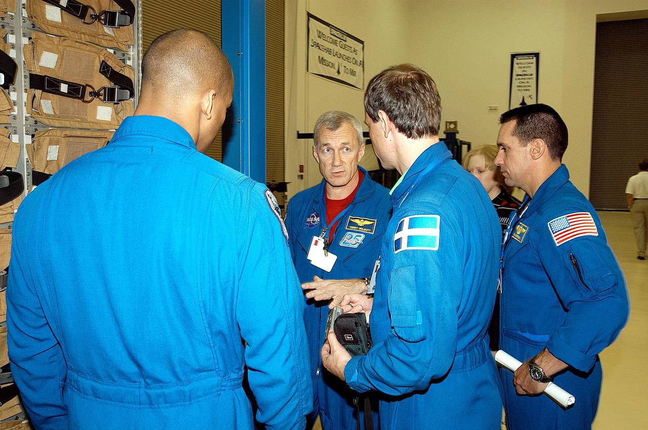 KENNEDY SPACE CENTER, FLA. - The STS-116 crew share thoughts during training at SPACEHAB in Port Canaveral, Fla. From left are Mission Specialist Robert Curbeam, Commander Terrence Wilcutt, Mission Specialist Christer Fuglesang and Pilot William Oefelein. Objective of their mission to the International Space Station is to deliver and attach the third port truss segment, the P5 Truss, deactivate and retract the P6 Truss Channel 4B (port-side) solar array, and reconfigure station power from 2A and 4A solar arrays. A launch date is under review.