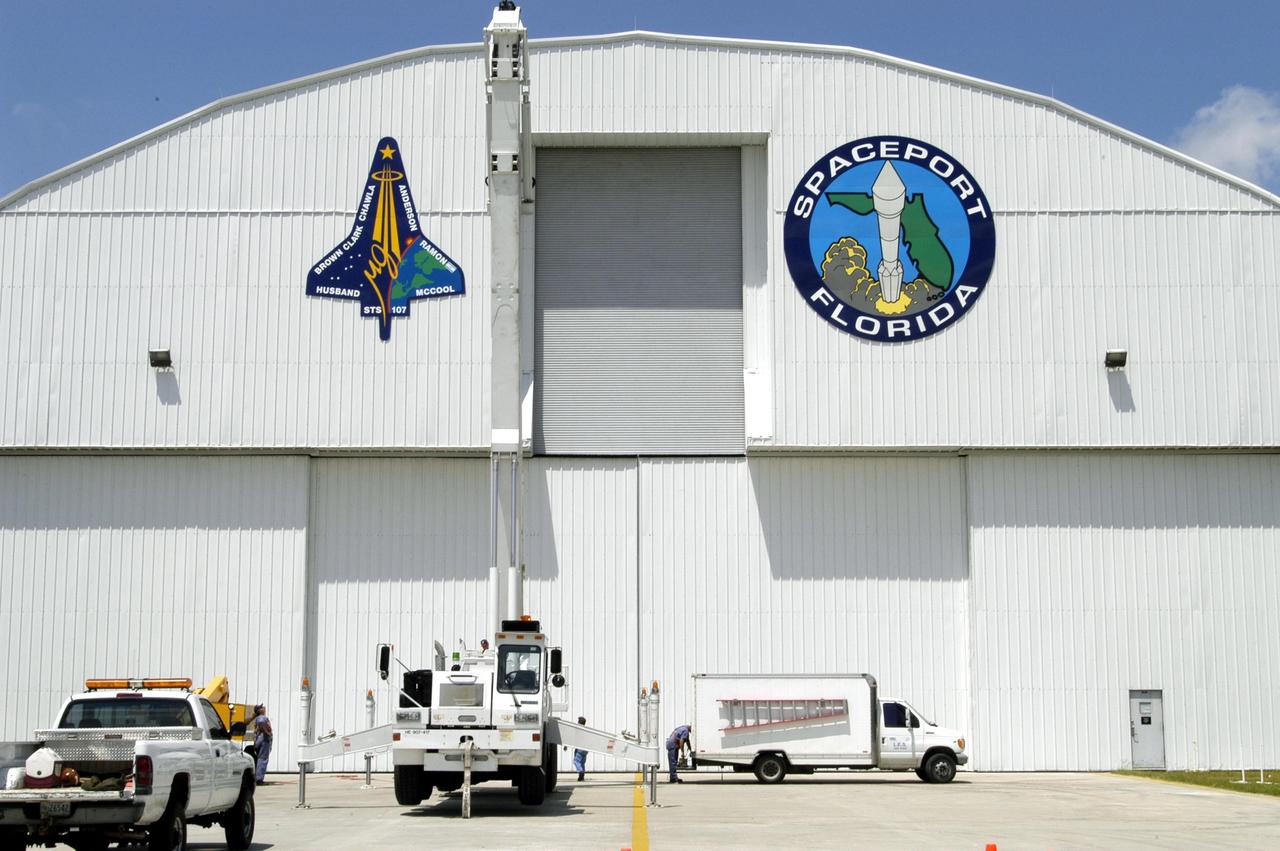 KENNEDY SPACE CENTER, FLA. - The mission patch for STS-107 is displayed, left, on the outside of the RLV Hangar at KSC.  The hangar is the site of the Columbia Reconstruction Project, where pieces of debris from Columbia are being collected and identified as part of the mishap investigation.