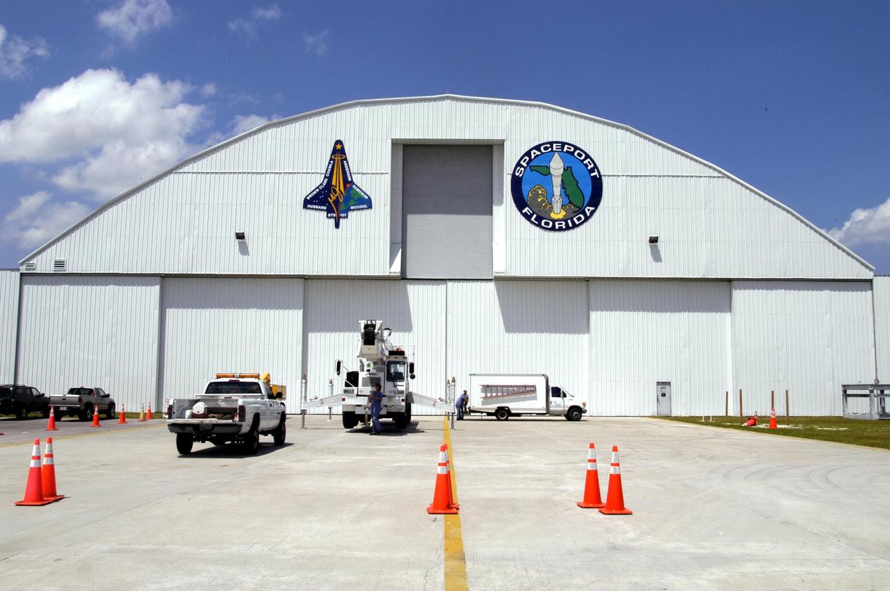 KENNEDY SPACE CENTER, FLA. - The mission patch for STS-107 is displayed, left, on the outside of the RLV Hangar at KSC.  The hangar is the site of the Columbia Reconstruction Project, where pieces of debris from Columbia are being collected and identified as part of the mishap investigation.