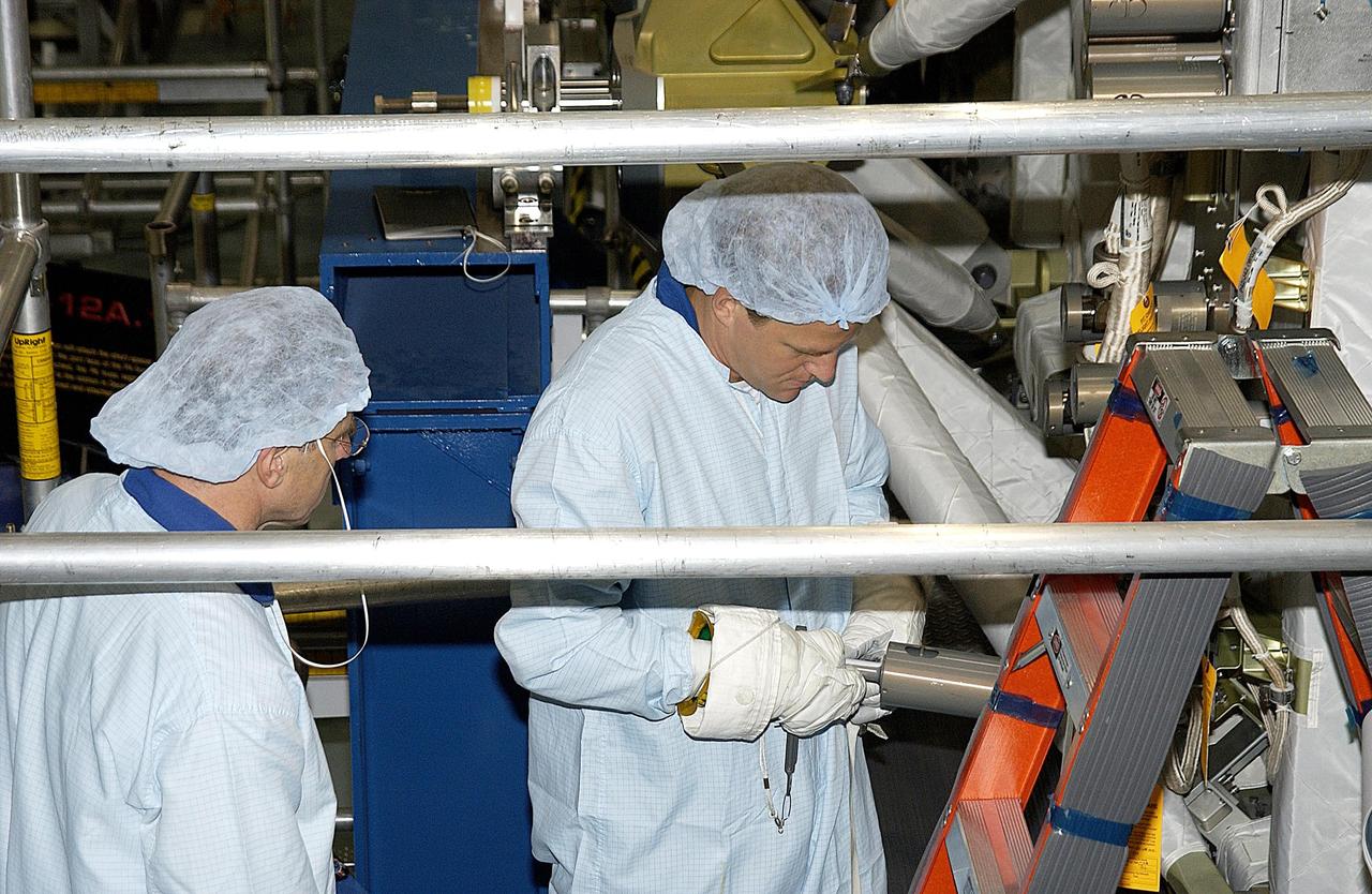 KENNEDY SPACE CENTER, FLA. - STS-118 Mission Specialist Scott Parazynski practices using equipment during training in the Space Station Processing Facility. At left is Mission Specialist Dafydd Williams, with the Canadian Space Agency. They and other crew members are at KSC to become familiar with equipment for their mission. The mission will be delivering the third starboard truss segment, the ITS S5, to the International Space Station, and a SPACEHAB Single Cargo Module with supplies and equipment. Launch date is under review.