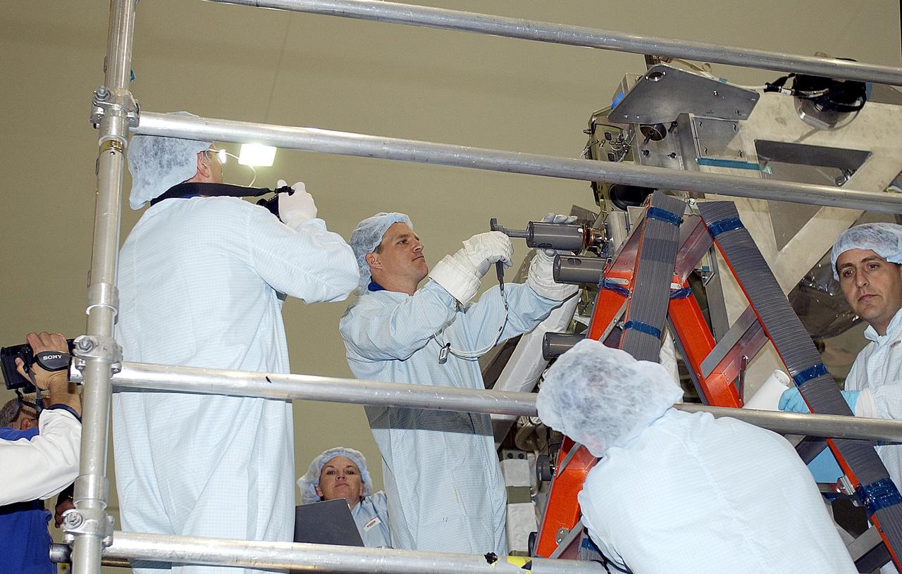 KENNEDY SPACE CENTER, FLA. - STS-118 Mission Specialists Dafydd Williams (left) and Scott Parazynski (center) practice using equipment during training in the Space Station Processing Facility. He and other crew members are at KSC to become familiar with equipment for their mission. The mission will be delivering the third starboard truss segment, the ITS S5, to the International Space Station, and a SPACEHAB Single Cargo Module with supplies and equipment. Launch date is under review.