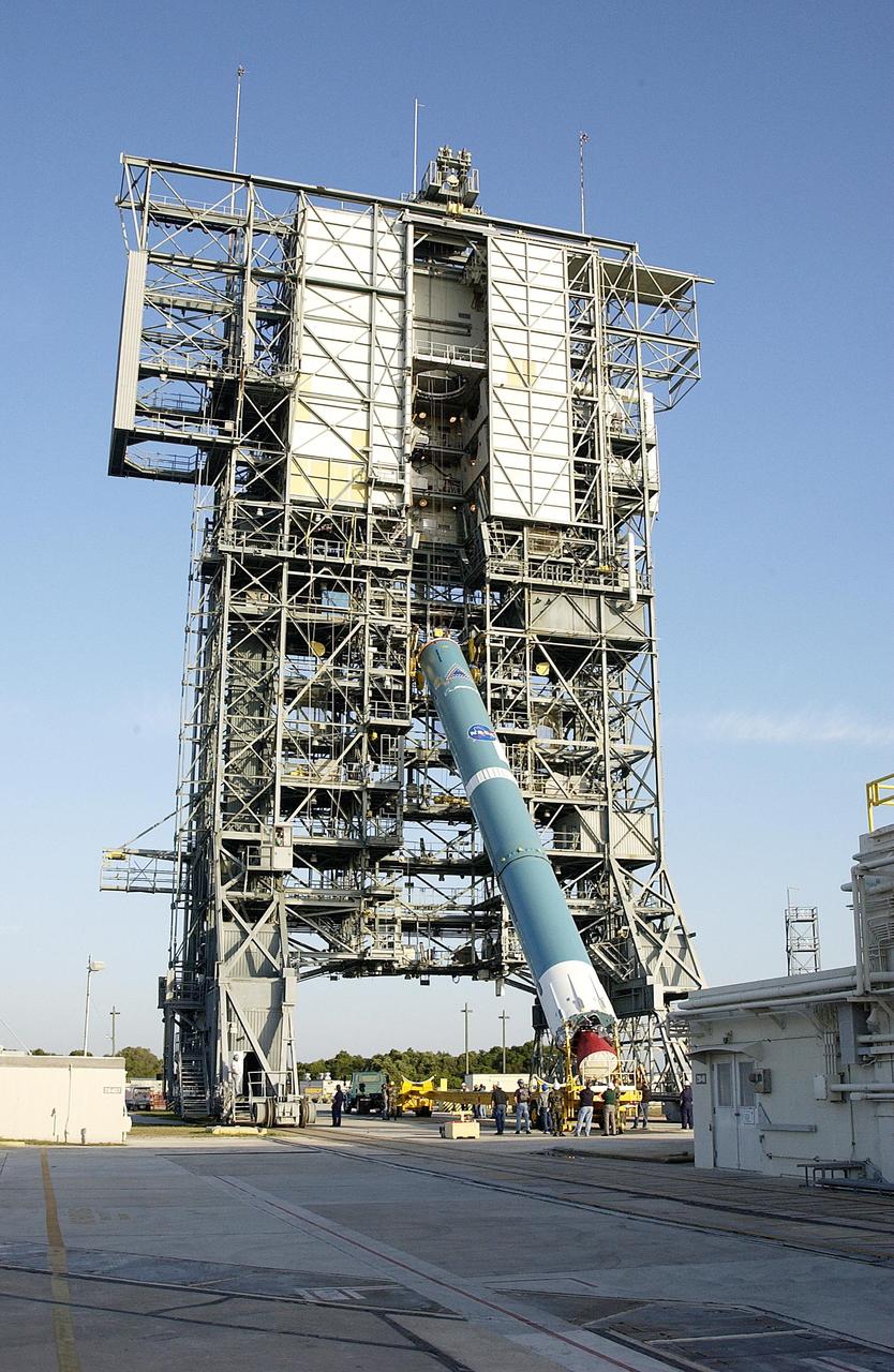 KENNEDY SPACE CENTER, FLA. - On Pad 17-A, Cape Canaveral Air Force Station, the first stage of the Delta II rocket is lifted to vertical at the launch tower. The Delta will launch the Mars Exploration Rover (MER-A) vehicle. The MER Mission consists of two identical rovers designed to cover roughly 110 yards each Martian day over various terrain. Each rover will carry five scientific instruments that will allow it to search for evidence of liquid water that may have been present in the planet's past.  Identical to each other, the rovers will land at different regions of Mars.  Launch date for this first of NASA's two Mars Exploration Rover missions is scheduled no earlier than June 6.