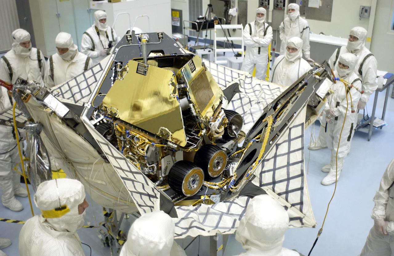 KENNEDY SPACE CENTER, FLA. - While workers watch the process, the petals on the lander close up around the Mars Exploration Rover 2 (MER-A).  The lander and rover will be enclosed within an aeroshell for launch.  The MER Mission consists of two identical rovers designed to cover roughly 110 yards each Martian day over various terrain. Each rover will carry five scientific instruments that will allow it to search for evidence of liquid water that may have been present in the planet's past.  Identical to each other, the rovers will land at different regions of Mars.  Launch date for this first of NASA's two Mars Exploration Rover missions is scheduled no earlier than June 6.