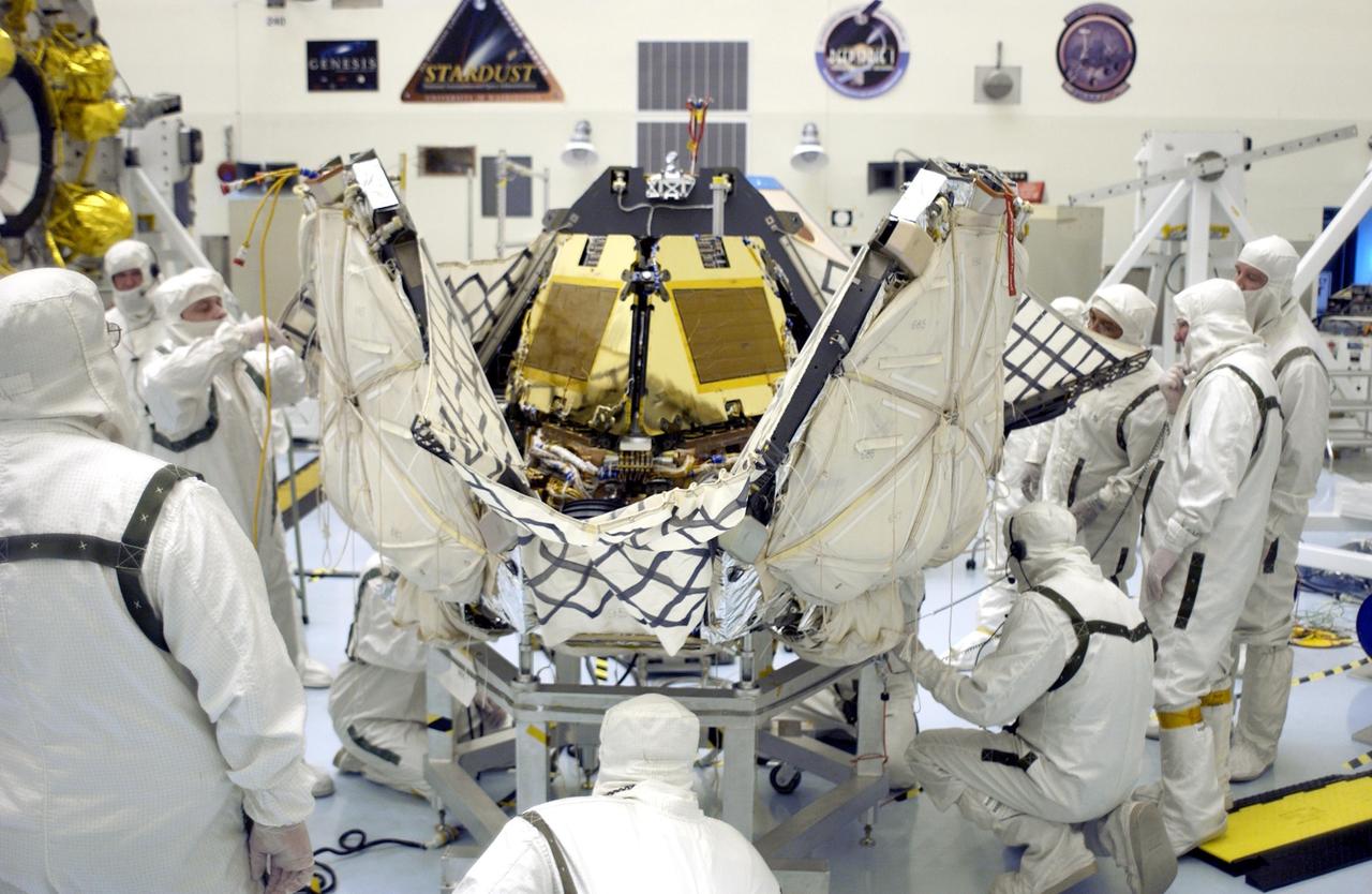 KENNEDY SPACE CENTER, FLA. -  Workers check different areas of the lander as the petals close in around the Mars Exploration Rover 2 (MER-A).  The lander and rover will subsequently be enclosed within an aeroshell for launch.  The MER Mission consists of two identical rovers designed to cover roughly 110 yards each Martian day over various terrain. Each rover will carry five scientific instruments that will allow it to search for evidence of liquid water that may have been present in the planet's past.  Identical to each other, the rovers will land at different regions of Mars.  Launch date for this first of NASA's two Mars Exploration Rover missions is scheduled no earlier than June 6.