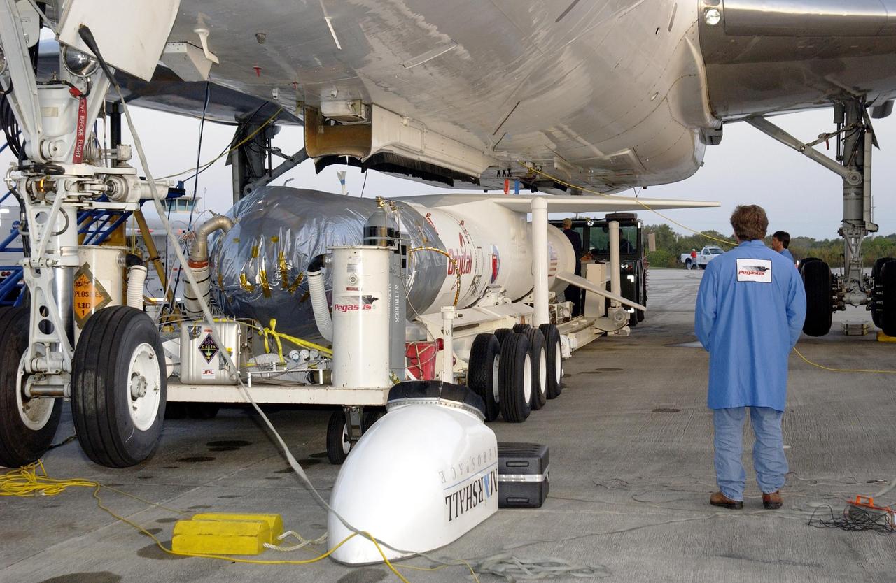 KENNEDY SPACE CENTER, FLA. - The mated Pegasus XL and Galaxy Evolution Explorer (GALEX) satellite are moved into position under the Orbital Sciences L-1011 aircraft at Cape Canaveral Air Force Station.  The GALEX, to be launched April 28 from the L-1011, will carry into space an orbiting telescope that will observe a million galaxies across 10 billion years of cosmic history to help astronomers determine when the stars and elements we see today had their origins. The spacecraft will sweep the skies for 28 months using state-of-the-art ultraviolet detectors to single out galaxies dominated by young, hot, short-lived stars that give off a great deal of energy at that wavelength.  These galaxies are actively creating stars, and therefore provide a window into the history and causes of star formation in galaxies.