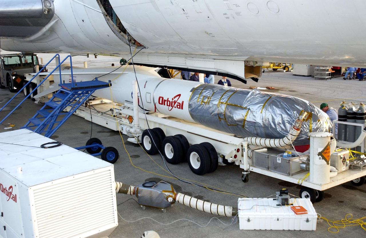 KENNEDY SPACE CENTER, FLA. - At Cape Canaveral Air Force Station, workers prepare to attach the mated Pegasus XL and Galaxy Evolution Explorer (GALEX) satellite to the Orbital Sciences L-1011 aircraft.  The GALEX, to be launched April 28 from the L-1011, will carry into space an orbiting telescope that will observe a million galaxies across 10 billion years of cosmic history to help astronomers determine when the stars and elements we see today had their origins. The spacecraft will sweep the skies for 28 months using state-of-the-art ultraviolet detectors to single out galaxies dominated by young, hot, short-lived stars that give off a great deal of energy at that wavelength.  These galaxies are actively creating stars, and therefore provide a window into the history and causes of star formation in galaxies.