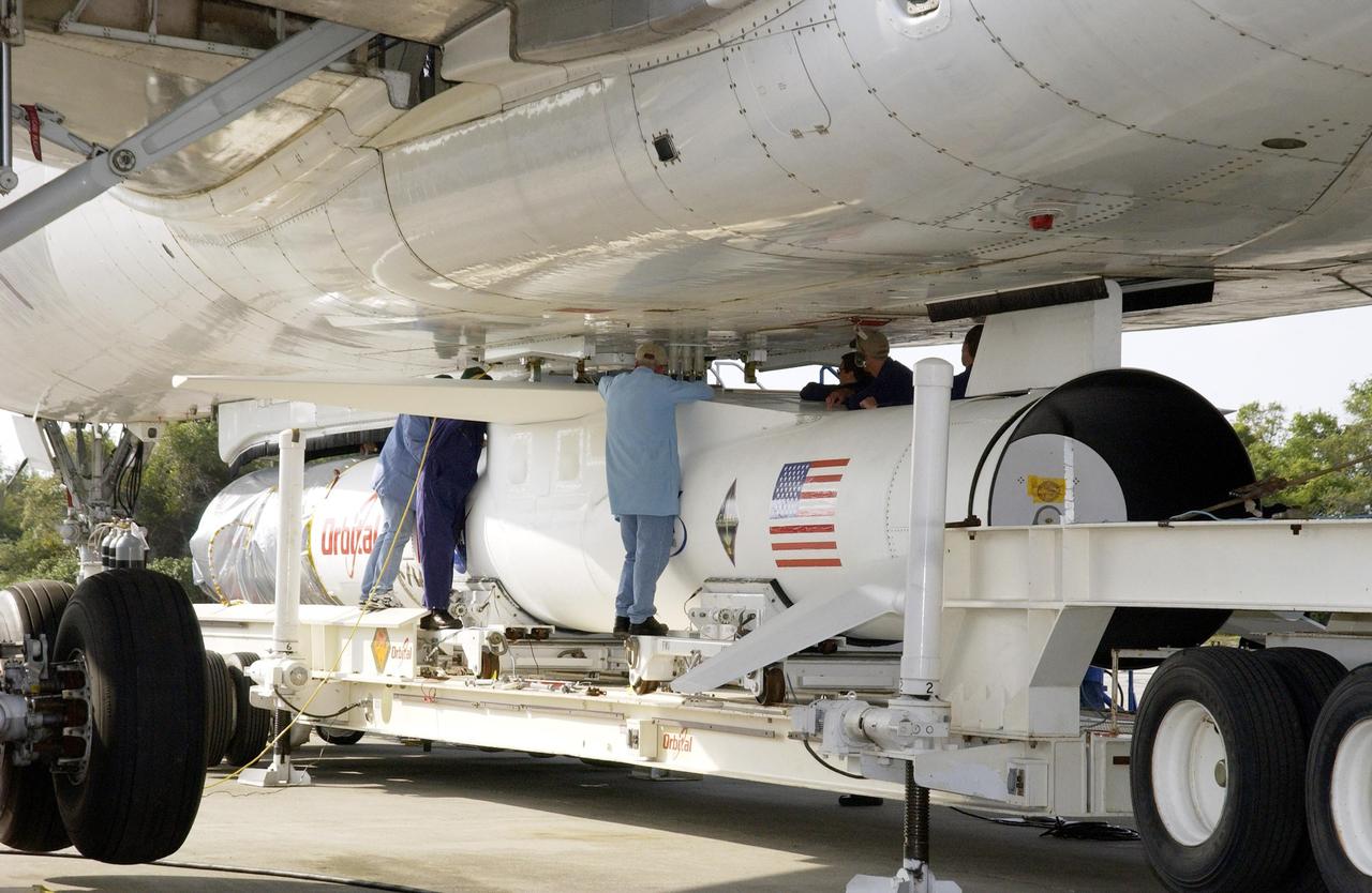 KENNEDY SPACE CENTER, FLA. - At Cape Canaveral Air Force Station, workers attach the mated Pegasus XL and Galaxy Evolution Explorer (GALEX) satellite to the Orbital Sciences L-1011 aircraft.  The GALEX, to be launched April 28 from the L-1011, will carry into space an orbiting telescope that will observe a million galaxies across 10 billion years of cosmic history to help astronomers determine when the stars and elements we see today had their origins. The spacecraft will sweep the skies for 28 months using state-of-the-art ultraviolet detectors to single out galaxies dominated by young, hot, short-lived stars that give off a great deal of energy at that wavelength.  These galaxies are actively creating stars, and therefore provide a window into the history and causes of star formation in galaxies.