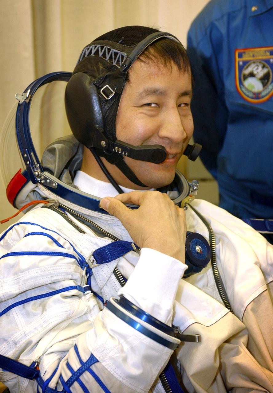 Baikonur Cosmodrome, Kazakhstan. Building 254, Soyuz Integration Facility.  Astronaut Edward T. Lu, NASA ISS science officer and flight engineer for Expedition Seven, dons his Russian Sokol suit for the leak check and Soyuz inspection, seat liner check.  Veteran Russian cosmonaut Yuri Malenchenko and veteran NASA astronaut Ed Lu have been named as the primary crew for the planned April 26, 2003, launch of a Russian Soyuz TMA-2 spacecraft to the International Space Station. Malenchenko and Lu will be called the Expedition 7 crew. Russian cosmonaut Alexander Kaleri and NASA astronaut Michael Foale are the backup crewmembers to Malenchenko and Lu.  Expedition 6 Commander Ken Bowersox, Flight Engineer Nikolai Budarin and NASA Space Station Science Officer Don Pettit will return to Earth aboard the Soyuz TMA-1 craft in May 2003. The three Expedition 6 crewmembers were launched on Nov. 23, 2002. They have been aboard the Station since November 25. They were originally scheduled to return in March aboard the Space Shuttle Atlantis during the STS-114 mission.  Malenchenko and Lu will continue to operate the science payloads already on board, as well as maintaining the Station.  Photo Credit: NASA/Bill Ingalls