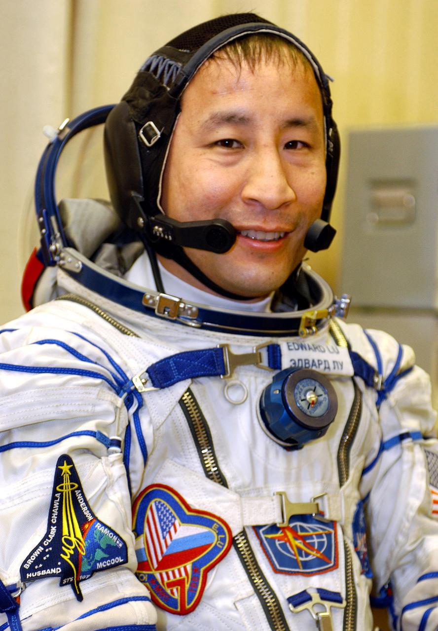 Baikonur Cosmodrome, Kazakhstan. Astronaut Edward T. Lu, NASA ISS science officer and flight engineer for Expedition Seven, smiles for a photo after donning his flight suit. Lu has an STS-107 patch on his suit in honor of the crew members lost on the Space Shuttle Columbia February 2003. Lu and fellow crew member Cosmonaut Yuri I. Malenchenko, Commander, were launched onboard a Soyuz rocket at 9:53 a.m. from Baikonur, Kazakhstan. Photo Credit: NASA/Bill Ingalls
