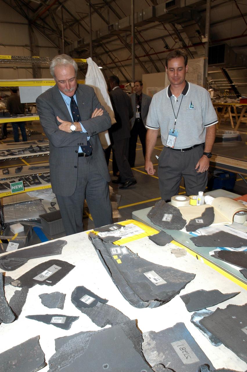 KENNEDY SPACE CENTER, FLA. - In the RLV Hangar, NASA Administrator Sean O'Keefe (left) looks over pieces of debris from the Space Shuttle Columbia with Shuttle Test Director Steve Altemus, a member of the Columbia Reconstruction Project Team.  To date, more than 70,000 items have been delivered to KSC for use in the ongoing mishap investigation.