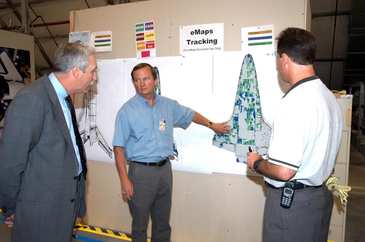 KENNEDY SPACE CENTER, FLA. - In the RLV Hangar, NASA Administrator Sean O'Keefe (left) is briefed on the status of the investigation into the Space Shuttle Columbia accident by Shuttle Launch Director Mike Leinbach (center) and Shuttle Test Director Steve Altemus (right), both members of the Columbia Reconstruction Project Team. To date, more than 70,000 items have been delivered to KSC for use in the ongoing mishap investigation.