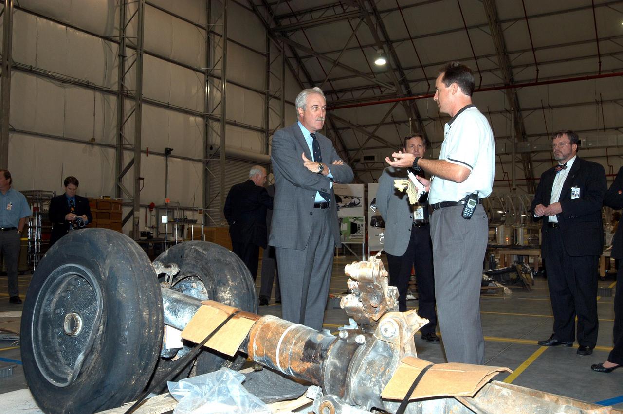 KENNEDY SPACE CENTER, FLA. - In the RLV Hangar, NASA Administrator Sean O'Keefe (left) listens to a report from Shuttle Test Director Steve Altemus, a member of the Columbia Reconstruction Project Team, on the status of the investigation into the Space Shuttle Columbia accident.  To date, more than 70,000 items have been delivered to KSC for use in the ongoing mishap investigation.