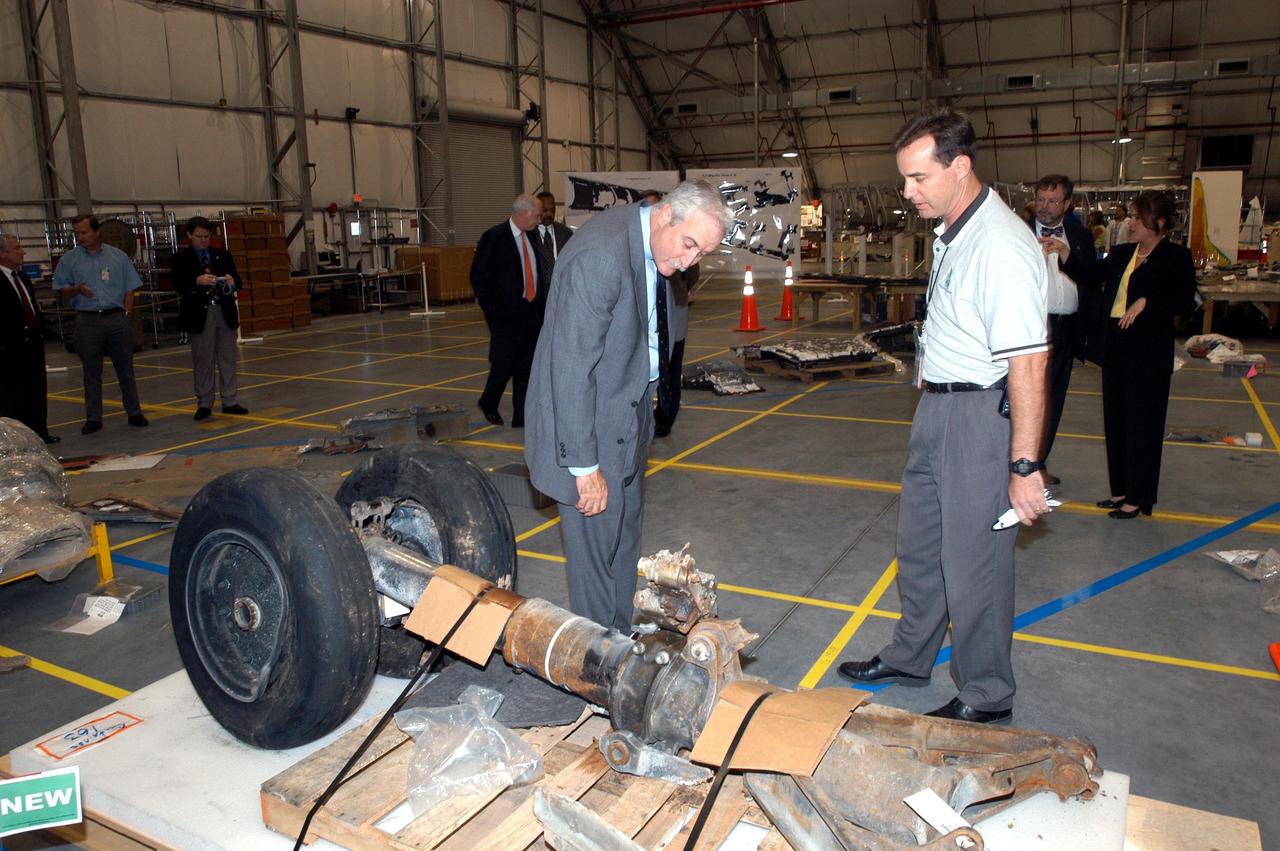 KENNEDY SPACE CENTER, FLA. - In the RLV Hangar, NASA Administrator Sean O'Keefe (left) looks over pieces of debris from the Space Shuttle Columbia with Shuttle Test Director Steve Altemus, a member of the Columbia Reconstruction Project Team. To date, more than 70,000 items have been delivered to KSC for use in the ongoing mishap investigation.