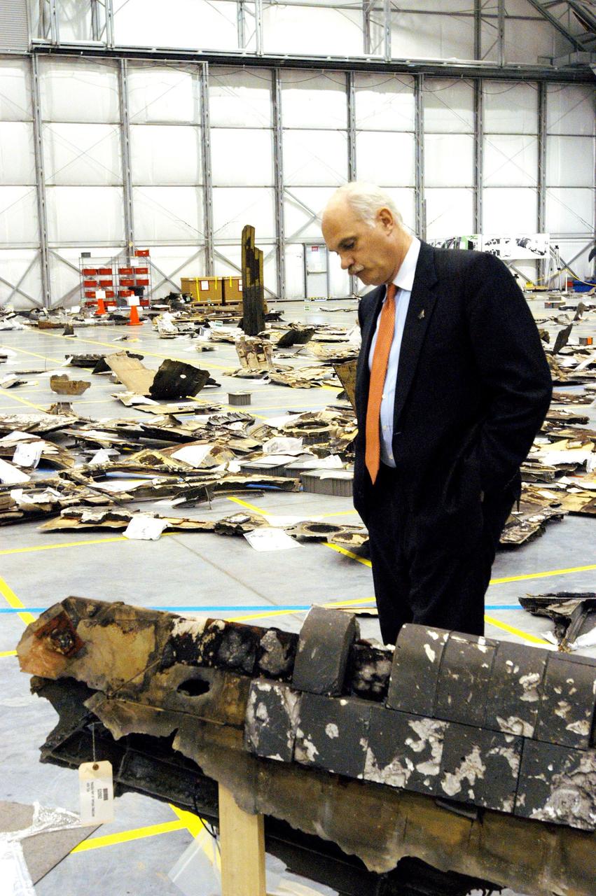 KENNEDY SPACE CENTER, FLA. - In the RLV Hangar, NASA Associate Administrator William F. (Bill) Readdy, Office of Space Flight, examines a piece of debris from Space Shuttle Columbia. To date, more than 70,000 items have been delivered to KSC for use in the ongoing mishap investigation.