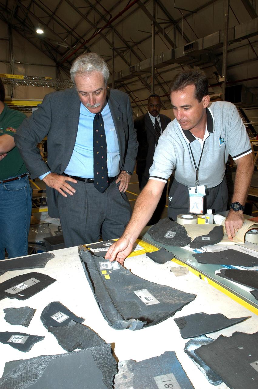KENNEDY SPACE CENTER, FLA. -  In the RLV Hangar, NASA Administrator Sean O'Keefe (left) looks over pieces of debris from the Space Shuttle Columbia with Shuttle Test Director Steve Altemus, a member of the Columbia Reconstruction Project Team. To date, more than 70,000 items have been delivered to KSC for use in the ongoing mishap investigation.