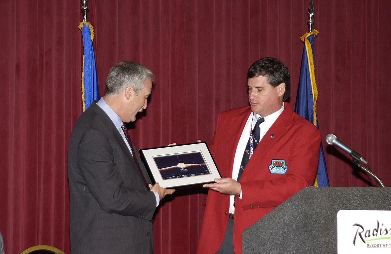 NASA Administrator Sean O'Keefe shakes hands with Kevin Hoshstrasser after presenting him with a framed photograph. Hoshstrasser is chairman of the 40th Space Congress held April 28-May 1, 2003, in Cape Canaveral, Fla. The international conference gathers attendees from the scientific community, the space industry workforce, educators and local supporting industries. This year's event commemorated the 40th anniversary of the Kennedy Space Center and the Centennial of Flight. The theme for the Space Congress was "Linking the Past to the Future: A Celebration of Space."