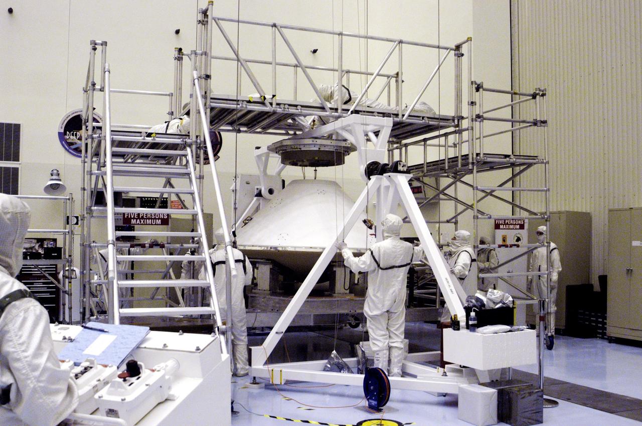 KENNEDY SPACE CENTER, FLA. - Workers in the Payload Hazardous Servicing Facility begin moving the aeroshell enclosing Mars Exploration Rover 2 and lander to a rotation table for a spin stabilization test.  There are two identical rovers that will land at different regions of Mars and are designed to cover roughly 110 yards each Martian day over various terrain. Each rover will carry five scientific instruments that will allow it to search for evidence of liquid water that may have been present in the planet's past.  The first rover, MER-A, is scheduled to launch June 5 from Cape Canaveral Air Force Station.  The second is scheduled for launch June 25.