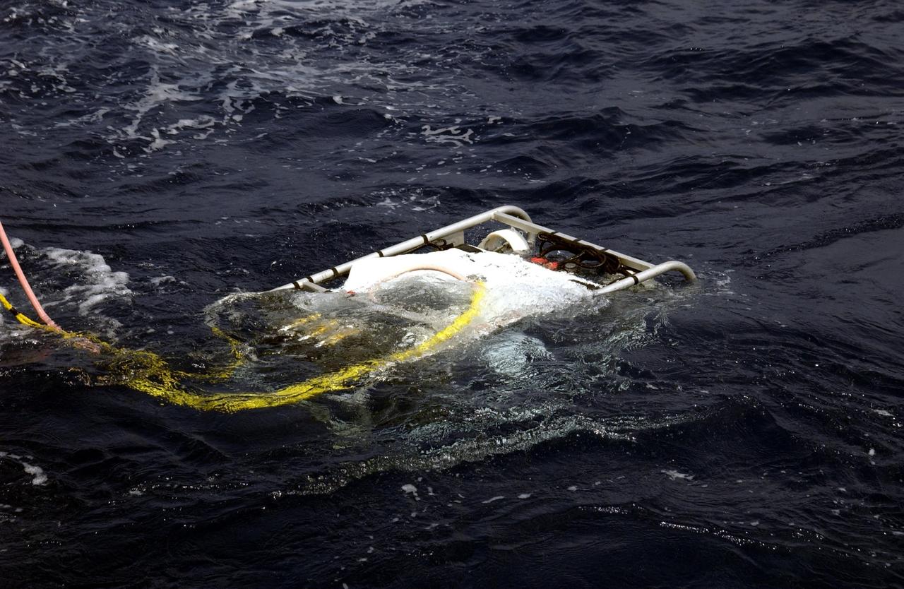KENNEDY SPACE CENTER, FLA. - Underwater research equipment slowly sinks into the water.  An undersea expedition is underway to characterize the condition of the deep-sea coral reefs and reef fish populations in the Oculina Banks, a marine protected area, 20 miles offshore of the east coast of Florida.  The equipment includes an underwater robot, a seafloor sampler, and the Passive Acoustic Monitoring System (PAMS), originally developed by NASA to monitor the impact of rocket launches on wildlife refuge lagoons at KSC.   The research is sponsored by NOAA Fisheries and will take place onboard the Liberty Star.  The ship departed from Port Canaveral April 29 and will return May 9.