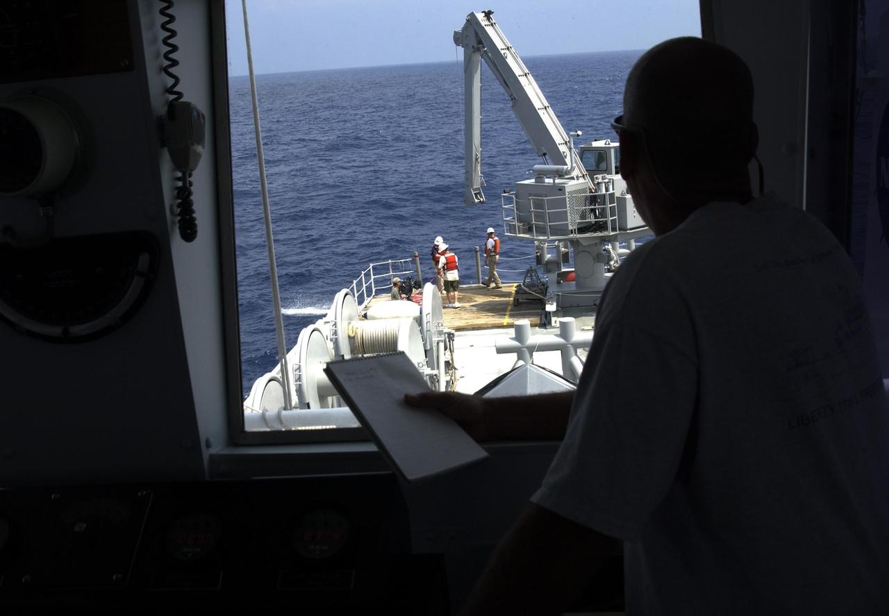 KENNEDY SPACE CENTER, FLA. -  A view from inside the pilot house of the Liberty Star overlooks the stern where a team secures lines to underwater research equipment being used on an expedition to characterize the condition of the deep-sea coral reefs and reef fish populations in the Oculina Banks.  The banks are a marine protected area, 20 miles offshore of the east coast of Florida.  The equipment includes an underwater robot, a seafloor sampler, and the Passive Acoustic Monitoring System (PAMS), originally developed by NASA to monitor the impact of rocket launches on wildlife refuge lagoons at KSC.   The research is sponsored by NOAA Fisheries.  The ship departed from Port Canaveral April 29 and will return May 9.