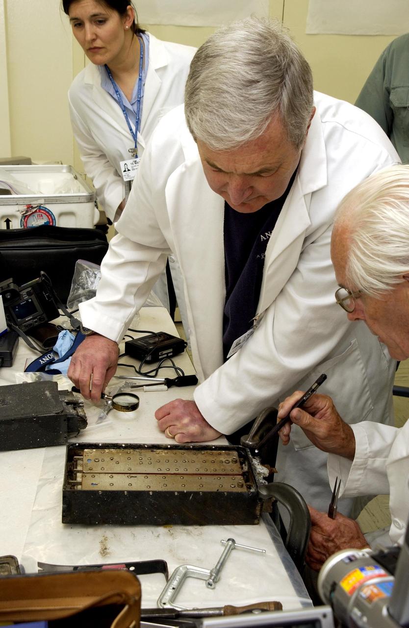 KENNEDY SPACE CENTER, FLA. -  John Cassanto of ITA looks at the Growth of Bacterial Biofilm on Surfaces during Spaceflight (GOBBSS) experiment that was carried on mission STS-107 as part of the Commercial ITA Biomedical Experiments payload.  He is part of a recovery team transferring experiments to alternate containers.  GOBBSS was a Planetary Society-sponsored astrobiology experiment developed by the Israeli Aerospace Medical Institute and the Johnson Space Center Astrobiology Center, with joint participation of an Israeli and a Palestinian student.  The recovery team also includes Eran Schenker of the Israeli Aerospace Medical Institute; David Warmflash of JSC, and Louis Friedman, executive director of the Planetary Society.  The GOBBSS material will be sent to JSC where the science team will analyze the samples, studying the effects of spaceflight on bacterial growth.