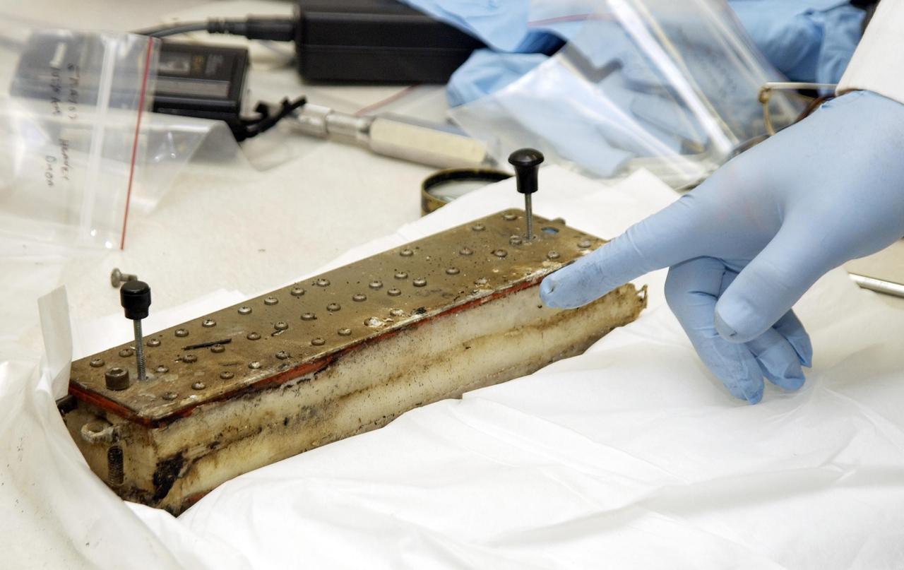 KENNEDY SPACE CENTER, FLA. - John Cassanto of ITA points to an area of the Growth of Bacterial Biofilm on Surfaces during Spaceflight (GOBBSS) experiment that was carried on mission STS-107 as part of the Commercial ITA Biomedical Experiments payload.  He is part of a recovery team transferring experiments to alternate containers.  GOBBSS was a Planetary Society-sponsored astrobiology experiment developed by the Israeli Aerospace Medical Institute and the Johnson Space Center Astrobiology Center, with joint participation of an Israeli and a Palestinian student.  The recovery team also includes Eran Schenker of the Israeli Aerospace Medical Institute; David Warmflash of JSC, and Louis Friedman, executive director of the Planetary Society.  The GOBBSS material will be sent to JSC where the science team will analyze the samples, studying the effects of spaceflight on bacterial growth.