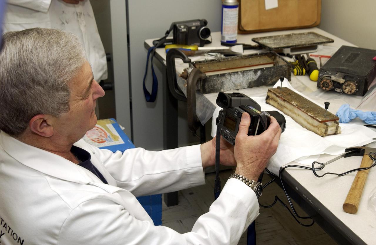 KENNEDY SPACE CENTER, FLA. - John Cassanto of ITA takes photos of the Growth of Bacterial Biofilm on Surfaces during Spaceflight (GOBBSS) experiment that was carried on mission STS-107 as part of the Commercial ITA Biomedical Experiments payload.  He is part of a recovery team transferring experiments to alternate containers.  GOBBSS was a Planetary Society-sponsored astrobiology experiment developed by the Israeli Aerospace Medical Institute and the Johnson Space Center Astrobiology Center, with joint participation of an Israeli and a Palestinian student.  The recovery team also includes Eran Schenker of the Israeli Aerospace Medical Institute; David Warmflash of JSC, and Louis Friedman, executive director of the Planetary Society.  The GOBBSS material will be sent to JSC where the science team will analyze the samples, studying the effects of spaceflight on bacterial growth.