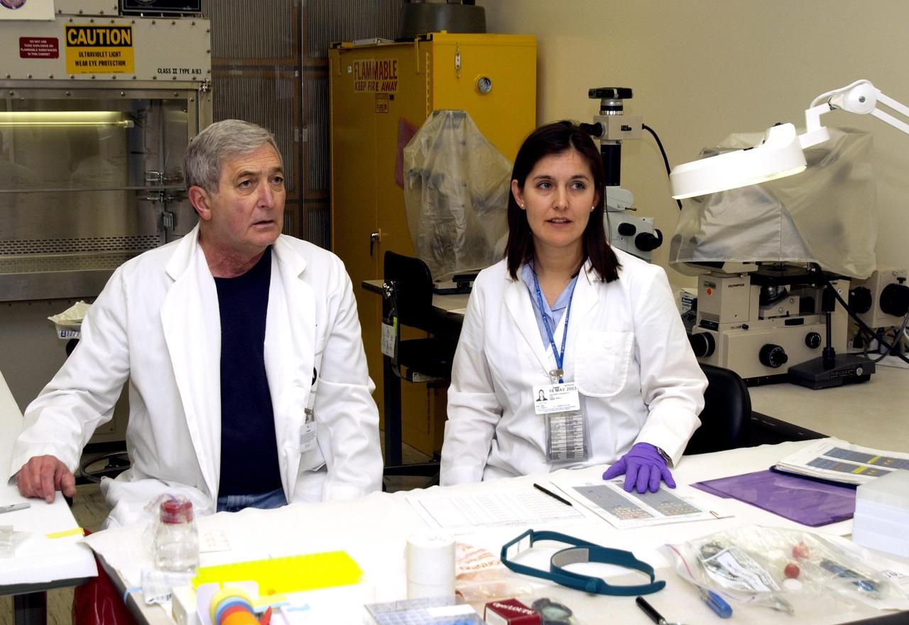 KENNEDY SPACE CENTER, FLA. - John Cassanto of ITA and his daughter Valerie stand next to the table holding the Growth of Bacterial Biofilm on Surfaces during Spaceflight (GOBBSS) experiment that was carried on mission STS-107 as part of the Commercial ITA Biomedical Experiments payload.  He is part of a recovery team transferring experiments to alternate containers.  GOBBSS was a Planetary Society-sponsored astrobiology experiment developed by the Israeli Aerospace Medical Institute and the Johnson Space Center Astrobiology Center, with joint participation of an Israeli and a Palestinian student.  The recovery team also includes Eran Schenker of the Israeli Aerospace Medical Institute; David Warmflash of JSC, and Louis Friedman, executive director of the Planetary Society.  The GOBBSS material will be sent to JSC where the science team will analyze the samples, studying the effects of spaceflight on bacterial growth.