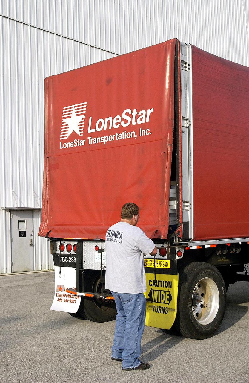 KENNEDY SPACE CENTER, FLA. - The truck holding the final shipment of Columbia debris arrives at KSC. The recovery efforts have been concluded in East Texas. Prior to this final shipment, the total number of items at KSC is 82,567, weighing 84,800 pounds or 38 percent of the total dry weight of Columbia. Of those items, 78,760 have been identified, with 753 placed on the left wing grid in the RLV Hangar.