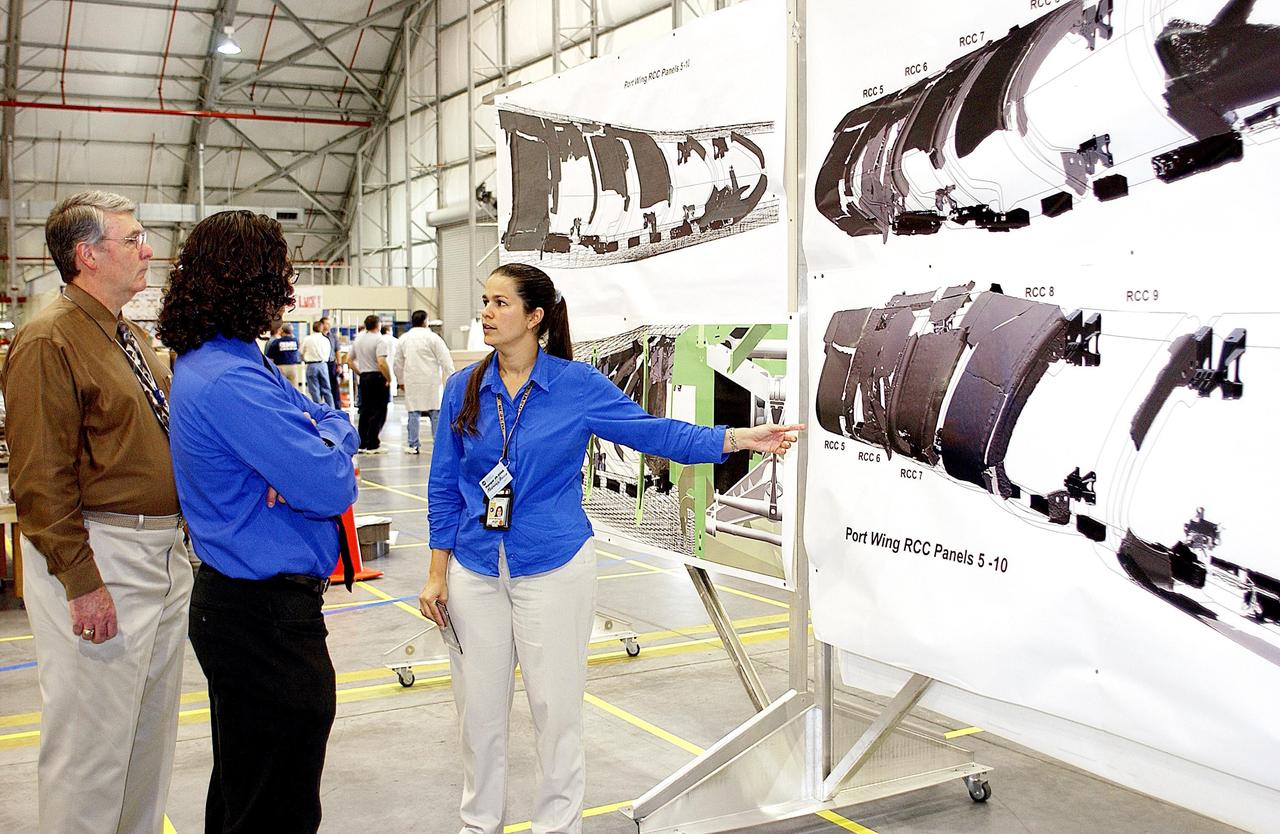 KENNEDY SPACE CENTER, FLA. - A member of the Columbia Reconstruction Project Team refers to the drawings of Columbia behind her as she explains current results of the investigation. The final shipment of debris arrived on this date - recovery efforts have been concluded in East Texas. Prior to this final shipment, the total number of items at KSC is 82,567, weighing 84,800 pounds or 38 percent of the total dry weight of Columbia. Of those items, 78,760 have been identified, with 753 placed on the left wing grid in the RLV Hangar.