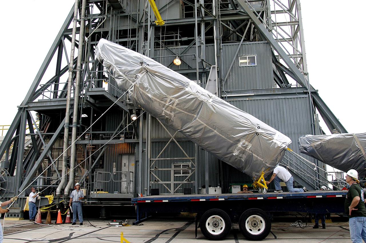 KENNEDY SPACE CENTER, FLA. - At Launch Complex 17-A, Cape Canaveral Air Force Station, the first half of the fairing for the Mars Exploration Rover 2 (MER-2/MER-A) is lifted off the transporter.  The fairing will be installed around the payload for protection during launch.  The MER Mission consists of two identical rovers designed to cover roughly 110 yards each Martian day over various terrain. Each rover will carry five scientific instruments that will allow it to search for evidence of liquid water that may have been present in the planet's past.  Identical to each other, the rovers will land at different regions of Mars.  Launch date for MER-A  is scheduled for June 5.