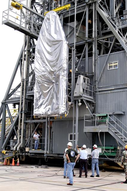 NASA image: KENNEDY SPACE CENTER, FLA. -  At Launch Complex 17-A, Cape Canaveral Air Force Station, the first half of the fairing for the Mars Exploration Rover 2 (MER-2/MER-A) is lifted up the launch tower.  The fairing will be installed around the payload for protection during launch.  The MER Mission consists of two identical rovers designed to cover roughly 110 yards each Martian day over various terrain. Each rover will carry five scientific instruments that will allow it to search for evidence of liquid water that may have been present in the planet's past.  Identical to each other, the rovers will land at different regions of Mars.  Launch date for MER-A  is scheduled for June 5.