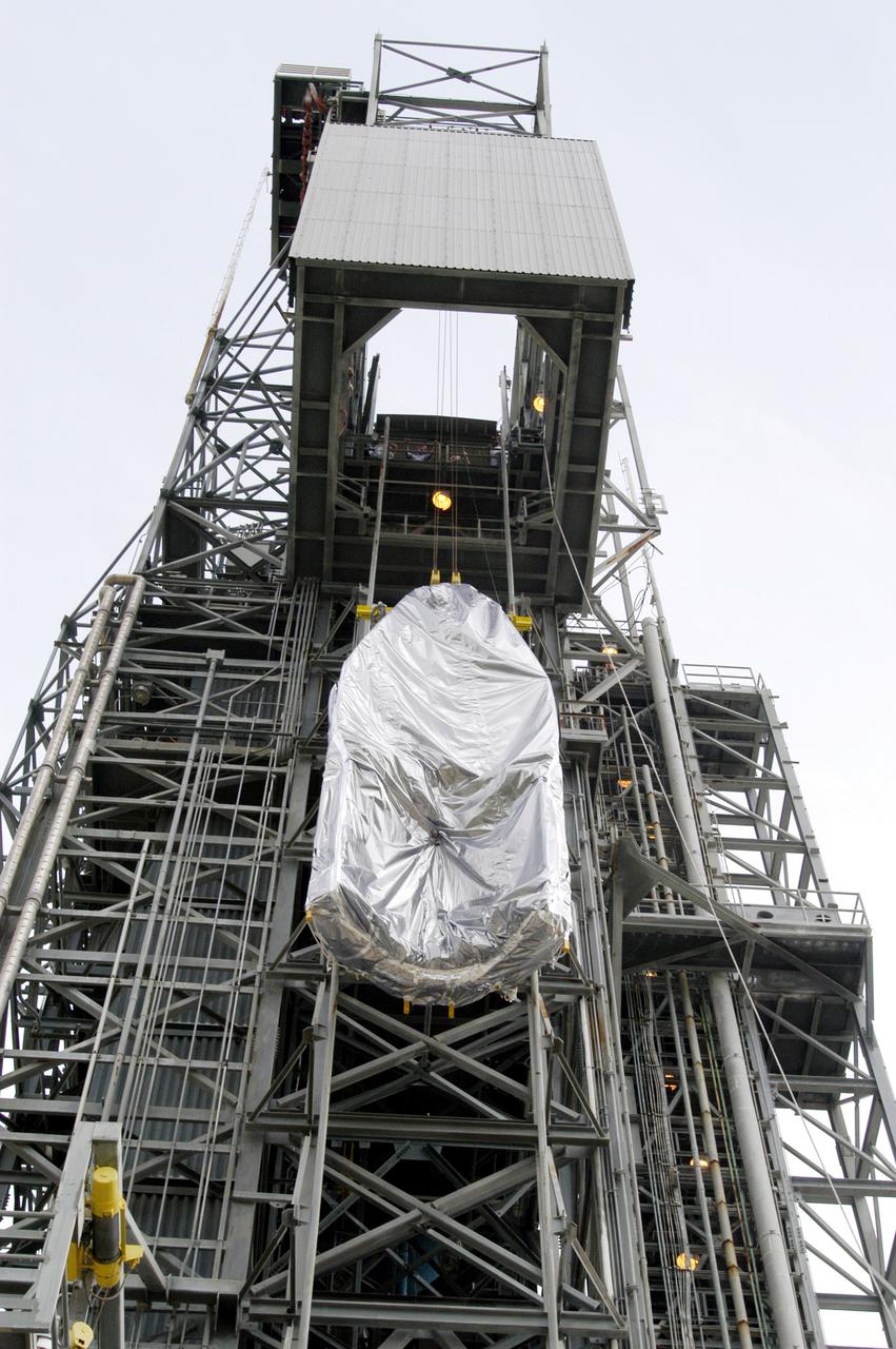 KENNEDY SPACE CENTER, FLA. -  At Launch Complex 17-A, Cape Canaveral Air Force Station, the first half of the fairing for the Mars Exploration Rover 2 (MER-2/MER-A) is lifted up the launch tower.  The fairing will be installed around the payload for protection during launch.  The MER Mission consists of two identical rovers designed to cover roughly 110 yards each Martian day over various terrain. Each rover will carry five scientific instruments that will allow it to search for evidence of liquid water that may have been present in the planet's past.  Identical to each other, the rovers will land at different regions of Mars.  Launch date for MER-A  is scheduled for June 5.